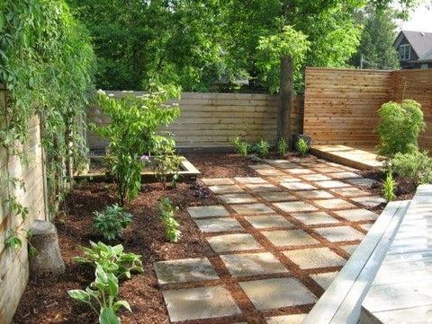 Backyard with mulch ground cover and garden beds replacing grass.