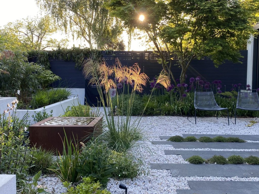 Backyard with pea gravel landscaping, patio furniture, and stepping stones instead of grass.