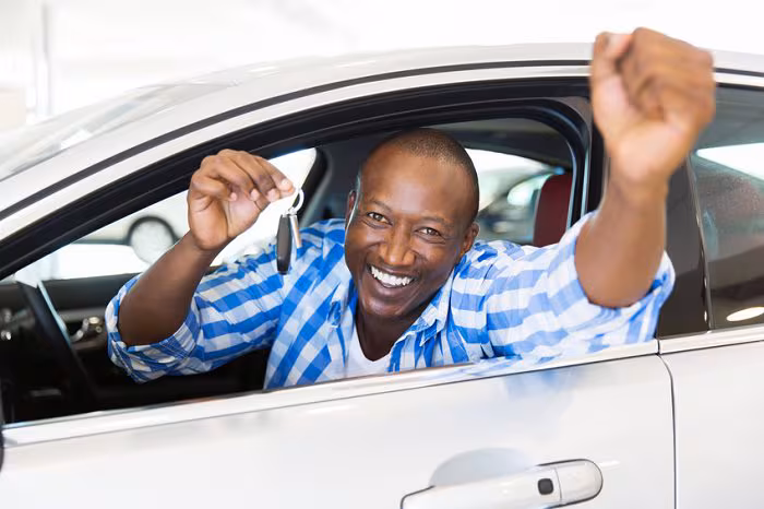 Happy BMW owner driving a used BMW sedan (cheap BMW)