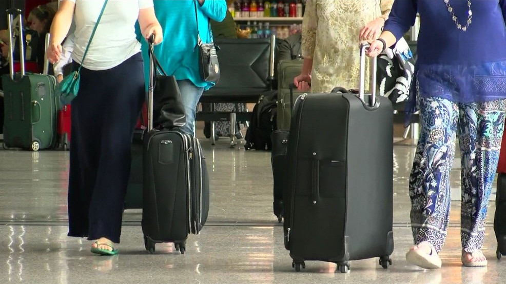 Traveler with suitcase inside Austin airport. (cheap flights from austin)