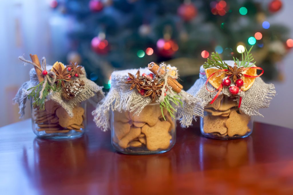 DIY cheap Christmas gifts displayed in jars with ribbons and tags.