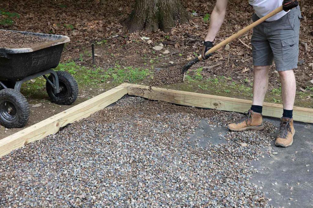DIY gravel patio installation in backyard replacing grass with seating area.