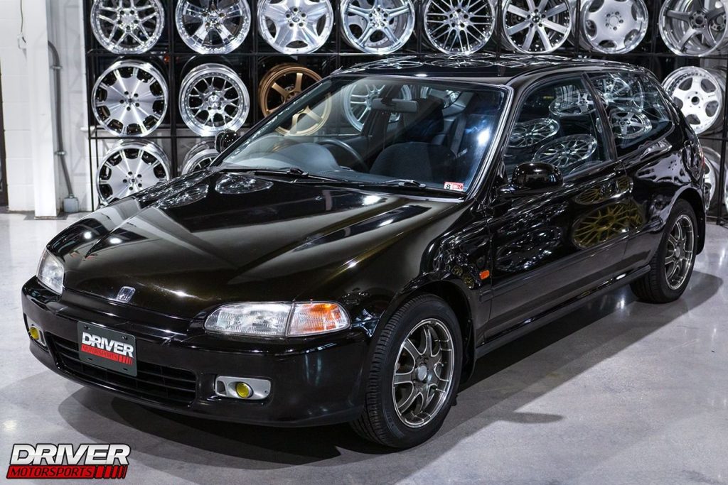 Black Honda Civic EG hatch in a garage.