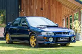 Blue Subaru Impreza WRX on grass.