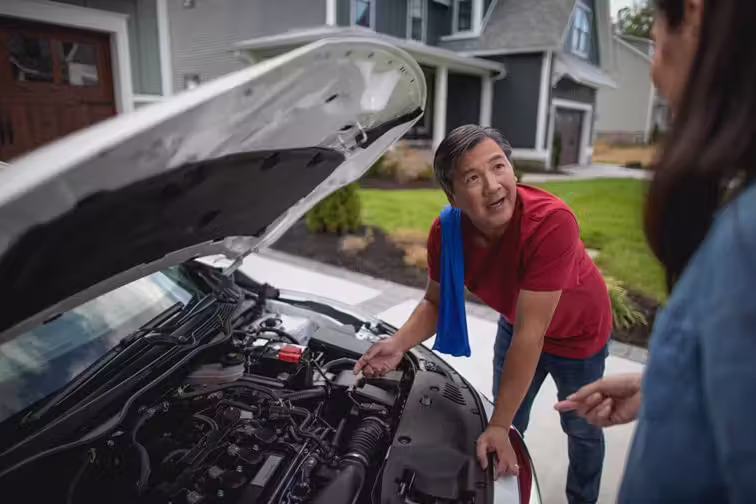 Buyer examining a used V8 vehicle in driveway