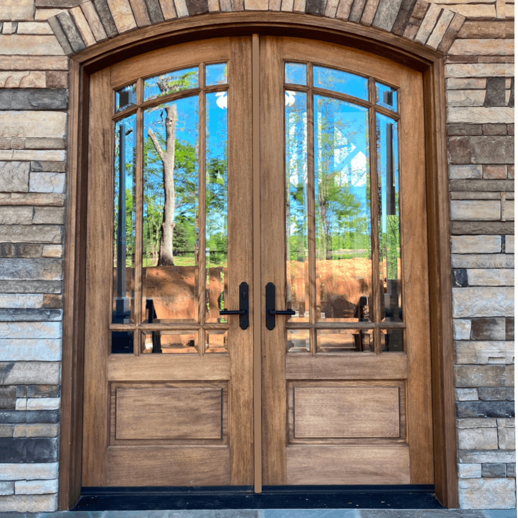 Exterior double doors with glass panels allowing natural sunlight into a home entryway