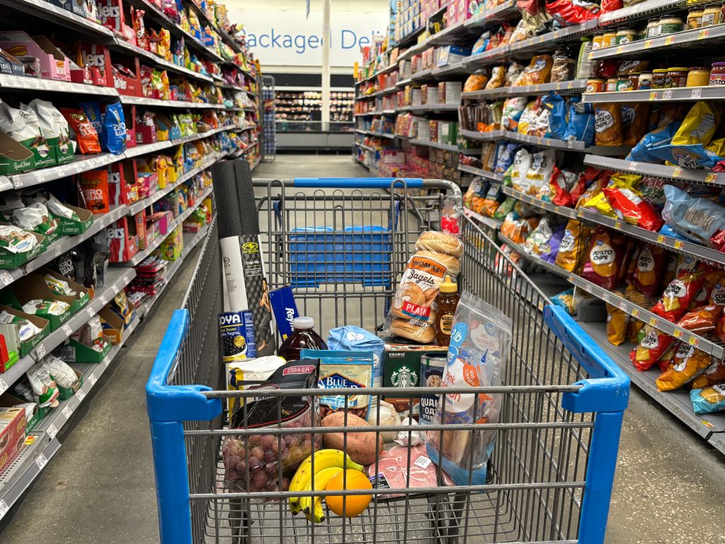 Grocery cart filled with affordable cheap food items in US supermarket