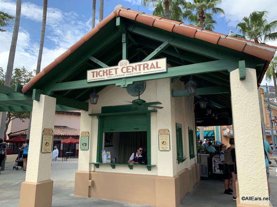 Disney World ticket booth in Hollywood Studios with a cast member assisting guests.