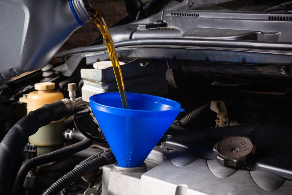 Maintaining a V8 engine with oil change and fluid checks in a garage