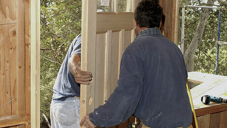 Contractor installing exterior double doors at a residential home entrance