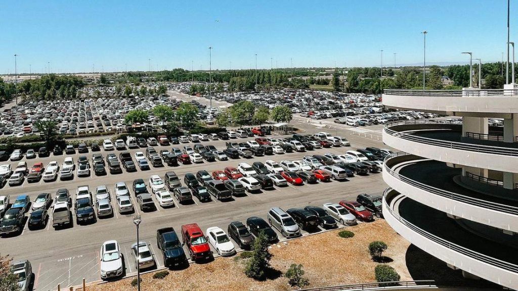 Large airport parking garage filled with cars near the terminal