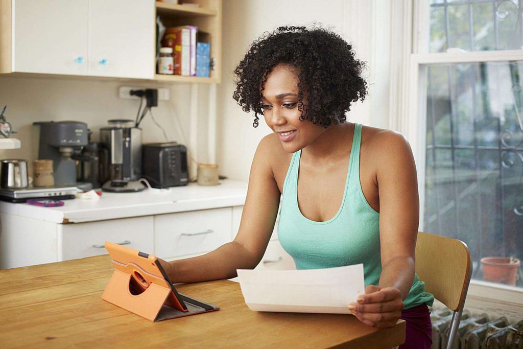 Person budgeting for rent at kitchen table