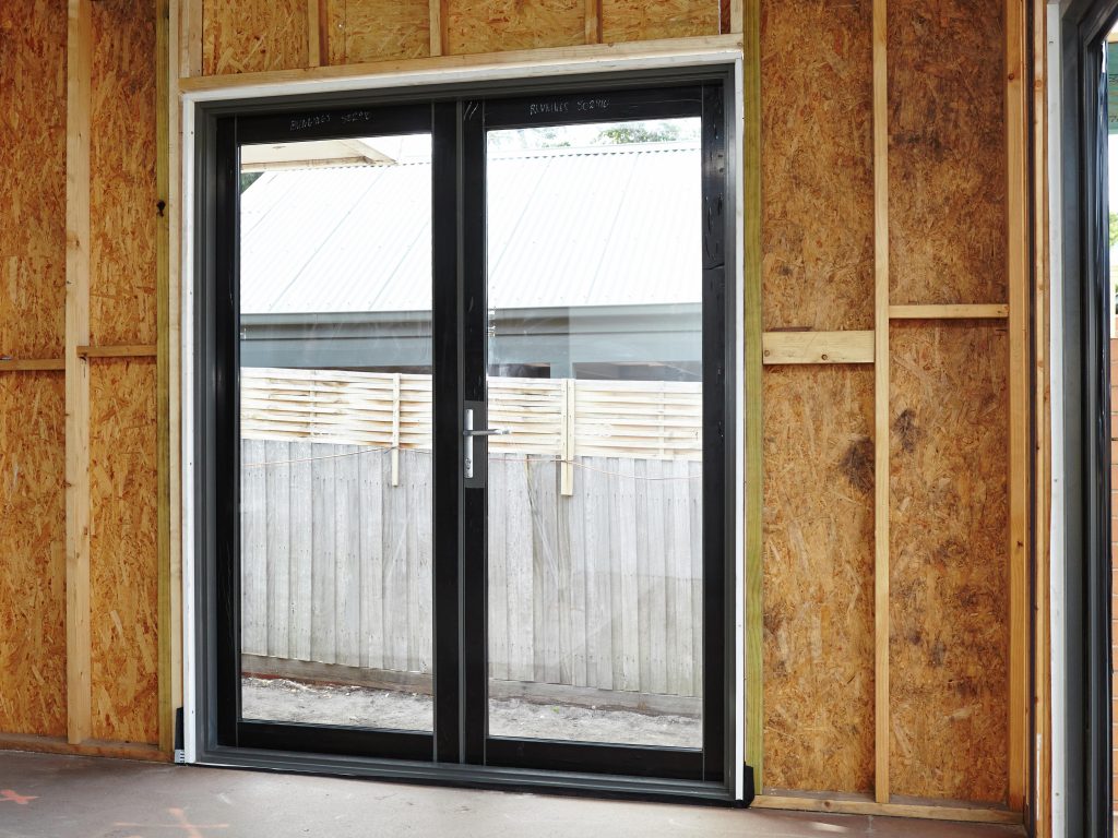 Pre hung exterior double doors with frame being installed during home renovation