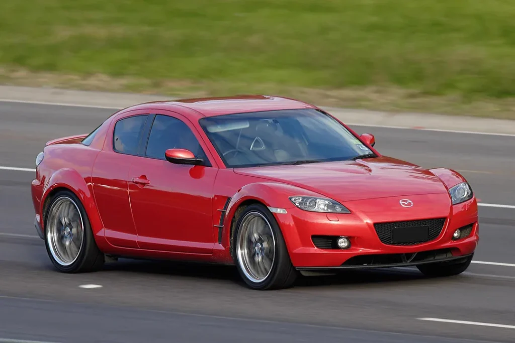 Red Mazda RX-8 on highway.