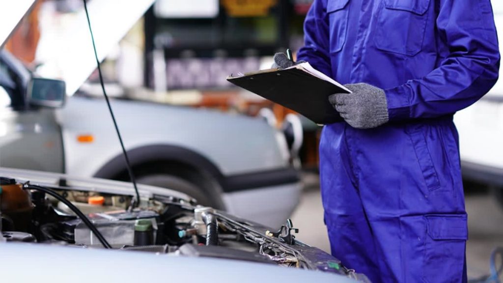 Mechanic using car diagnostic tool to check vehicle issues