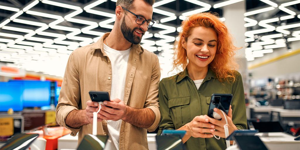 shopper comparing budget smartphones while choosing a cheap phone under $100