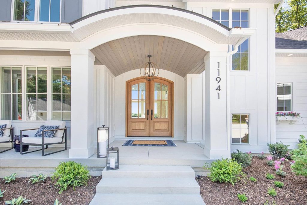 Traditional wood exterior double doors with natural finish at a home entrance