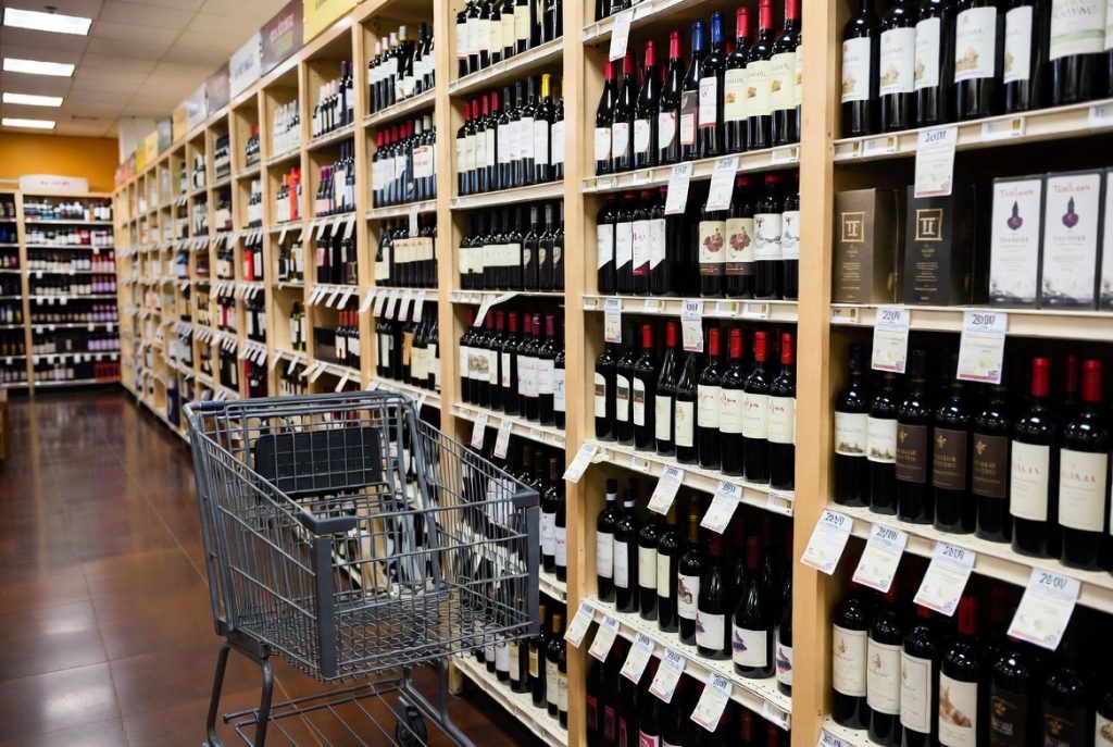 Inside a US wine store showing affordable red wine selection and price tags.
