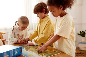 Three children focused on assembling a colorful jigsaw puzzle together at a wooden table with puzzle box visible, representing affordable puzzles great for kids and beginners.